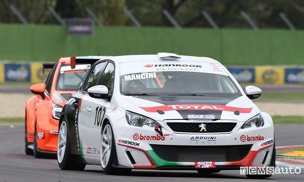 Pilota in pista a bordo di un'auto durante la corsa. Al pilota mentre è in gara aumentano battito cardiaco e respirazione. Potrebbe anche arrivare a digrignare i denti che si può evitare con il bite