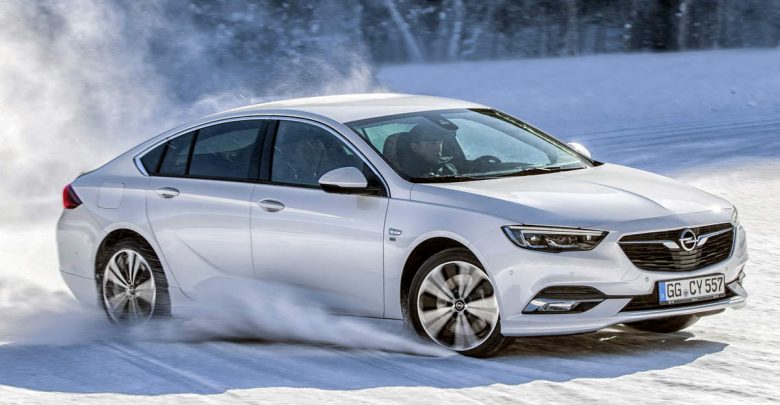 Opel Insignia Grand Sport bianca su neve drifting, si vede la coppia motrice e relativa distribuzione sulle 4 ruote. 