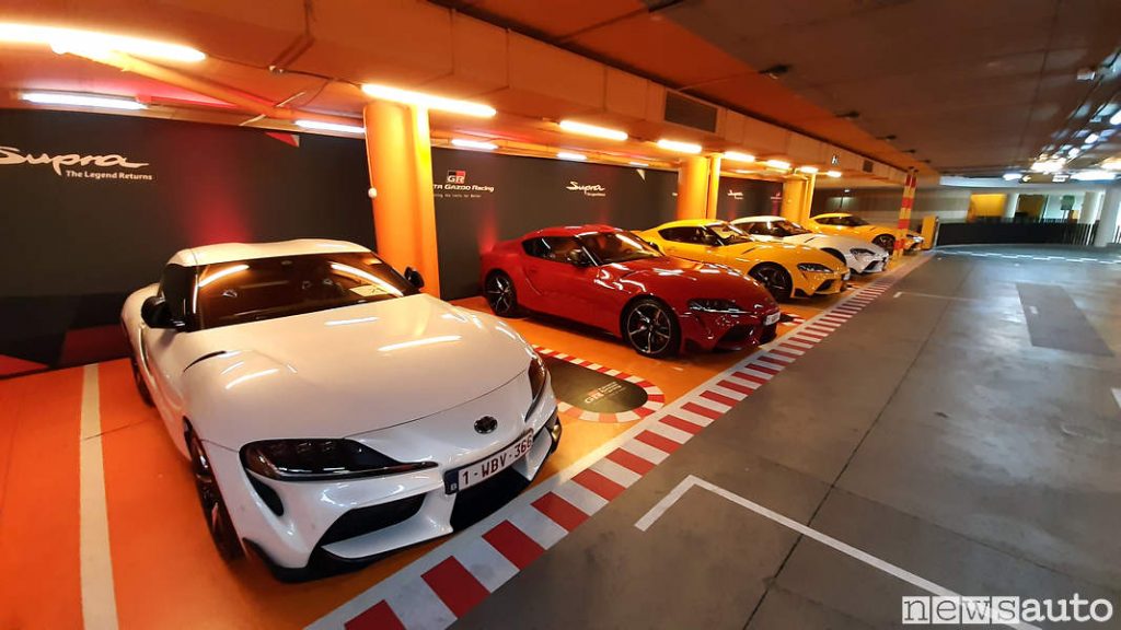 Garage con Toyota Supra bianca, rossa e gialla