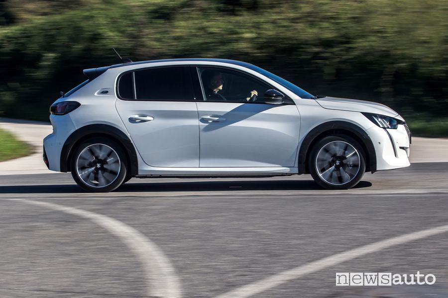Vista laterale Peugeot e-208 elettrica su strada