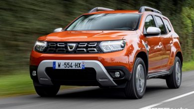 Vista di profilo nuovo Dacia Duster 4x2 Arizona Orange su strada