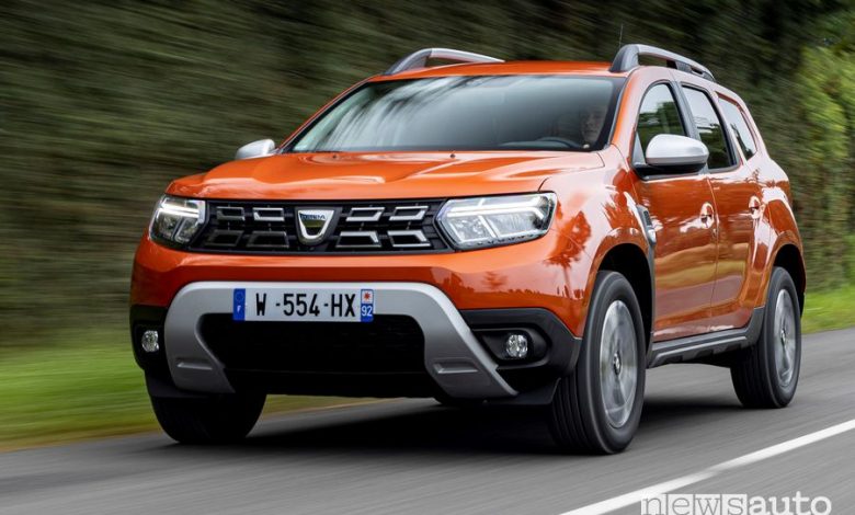 Vista di profilo nuovo Dacia Duster 4x2 Arizona Orange su strada