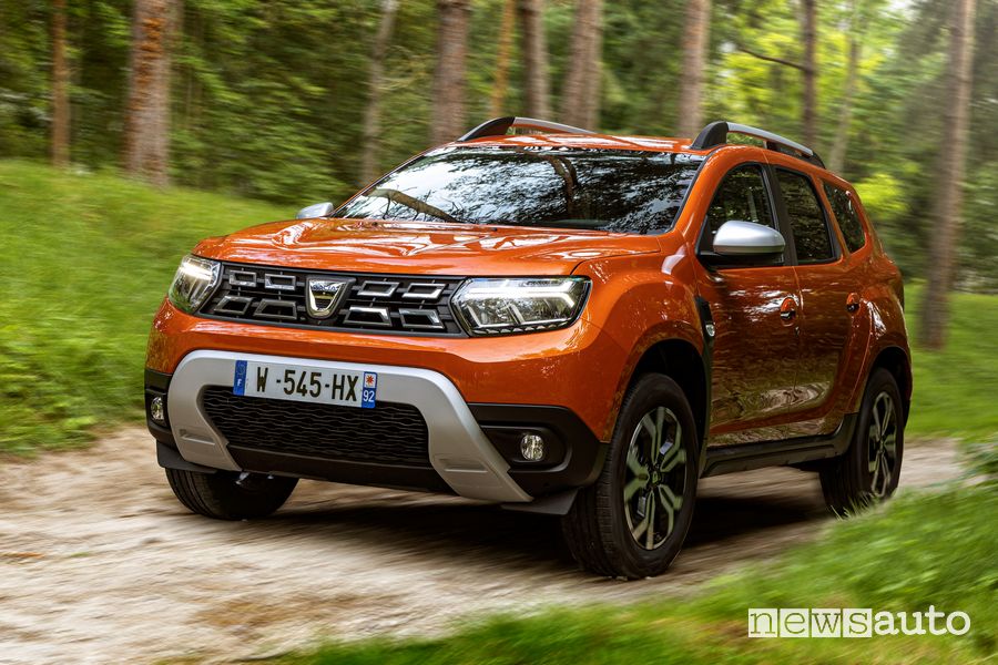 Vista di profilo nuovo Dacia Duster 4x2 Arizona Orange sullo sterrato