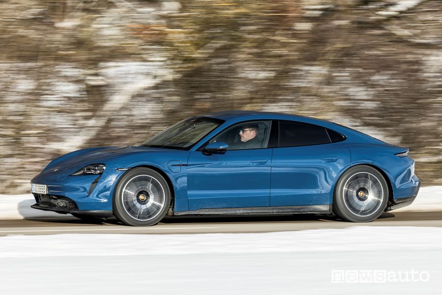 Vista laterale Porsche Taycan elettrica blu su strada
