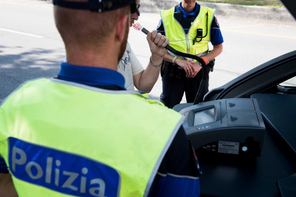 Un agente della Polizia mentre esegue un alcoltest per controllare se si è alla guida in stato di ebbrezza