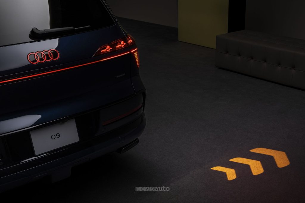Audi Q9 frecce proiettate sull'asfalto